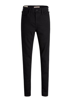 Czarne, wysokie dżinsy skinny z przodu zapinane na guzik i kieszeniami, wyeksponowane na białym tle.