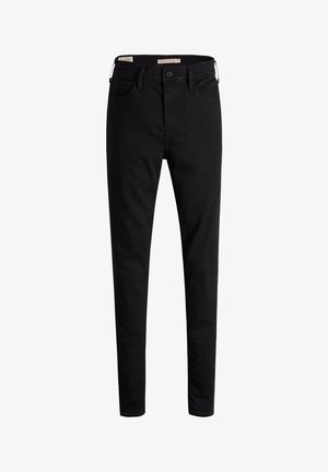 Czarne, wysokie dżinsy skinny z przodu zapinane na guzik i kieszeniami, wyeksponowane na białym tle.