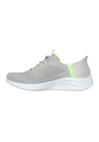 Grijze sportieve schoenen gemaakt van ademend gaas, met een witte zool en een neon groene accent bij de hiel, voorzien van een gestructureerde achterkant.