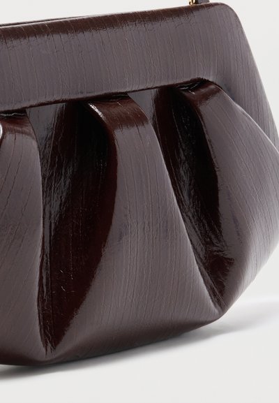 Σκούρο καφέ γυαλιστερό δερμάτινο τσαντάκι χειρός με πτυχώσεις και δομημένο πλαίσιο σε απλό λευκό φόντο.