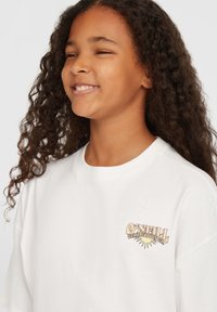 Bílá bavlněná tričko s krátkými rukávy, s barevným logem O'Neill Surf Supply Co. potisknutým na levé straně hrudi.