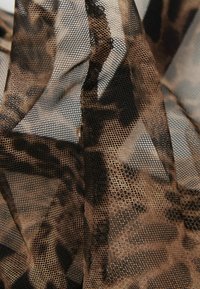 Transparante gaasstof met een luipaardprint in bruintinten, met een fijne netstructuur en een zachte, vloeiende textuur.