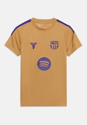 Maillot de sport doré à manches courtes avec des détails violets, présentant les logos du FC Barcelone et de Nike ainsi qu'un grand logo violet Spotify à l'avant.