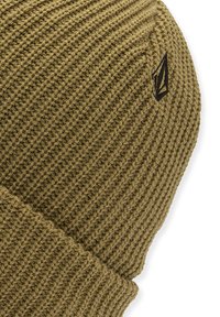 Bonnet en tricot de couleur vert olive, avec un tissu texturé, un revers roulé et un petit logo noir sur le côté.