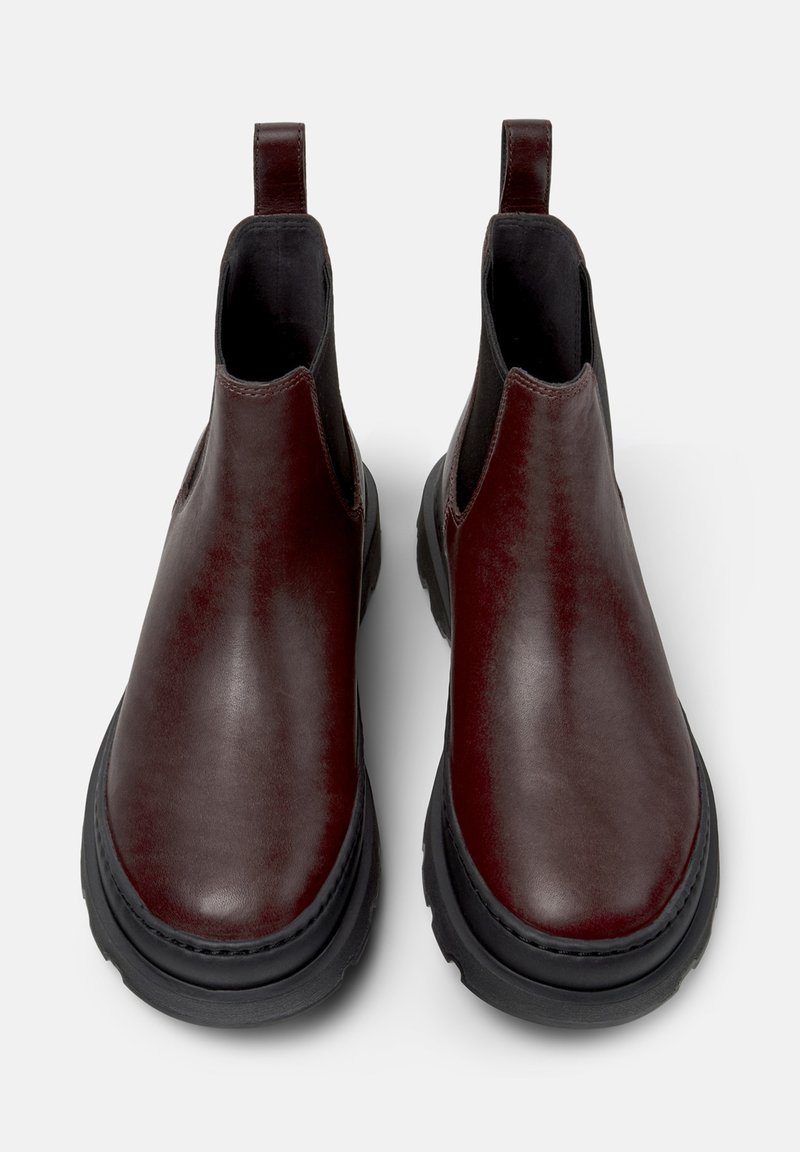 Burgundy leather chelsea boots with elastic side panels, pull tabs, and black rubber soles. Smooth texture with slight sheen.