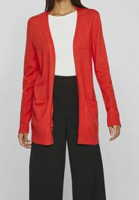 Röd stickad cardigan med lös passform, öppen framsida, långa ärmar och två framfickor. Texturerad tyg med ribbade mudd och nederkant.