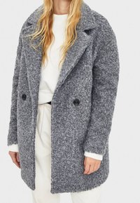 Gray boucle coat with a notched collar, double-button front, and side pockets. Features long sleeves and a textured, cozy material.