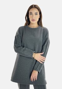 Felpa grigia a maniche lunghe con colletto tondo, vestibilità comoda e dettagli a coste sulle maniche. Tessuto morbido e design lungo fino al ginocchio.
