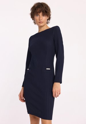 Granatowa sukienka prążkowana z długimi rękawami, dopasowanym fasonem i dwoma przednimi kieszeniami ozdobionymi złotymi elementami. Gładka tekstura i minimalistyczny design.