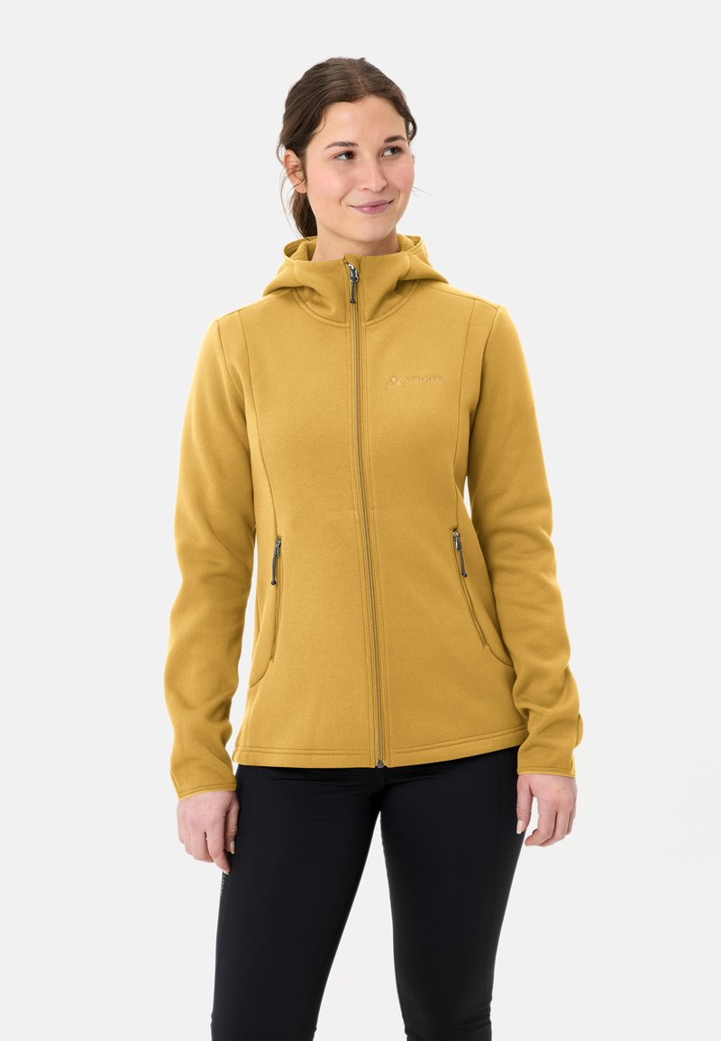 Fleeced vest in mosterdgeel, met een ritssluiting aan de voorkant, capuchon en twee ritssluitingen in de zakken. Soepele textuur, sportieve pasvorm en logo op de borst.