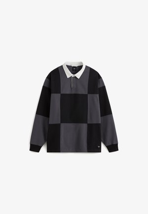 Koszulka polo z długim rękawem, charakteryzująca się patchworkowym wzorem w odcieniach szarości i czerni, z białym kołnierzykiem i zapięciem na guziki. Wykonana z miękkiej bawełny.