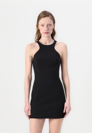 Robe noire sans manches avec une coupe ajustée, dotée d'un col montant et d'une bordure blanche contrastante le long des bords et des emmanchures.