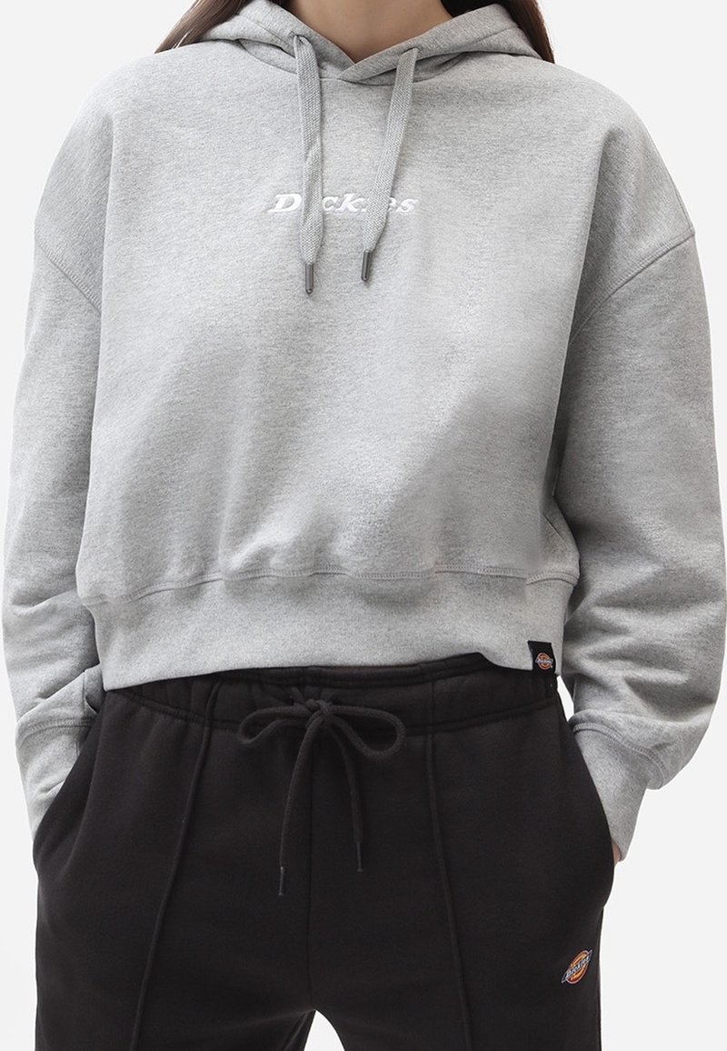 Hoodie grigio corto con coulisse, caratterizzato dal logo "Dickies" ricamato in bianco, abbinato a pantaloni felpati neri con vita regolabile.