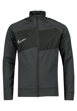 Veste zippée gris foncé en tissu lisse avec un panneau en mesh sur la poitrine, présentant un logo Nike blanc et des poches latérales.