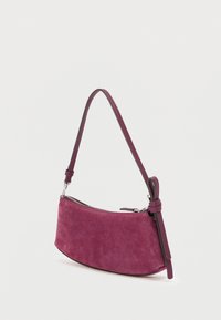 Sac à main en daim violet profond avec une forme courbée, une bandoulière réglable unique et une fermeture éclair, agrémenté d'accents en cuir ton sur ton.
