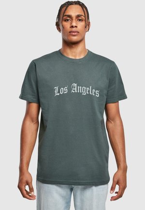 Tume roheline puuvillane T-särk, millel on ümmargune kaelus ja lühikesed varrukad, millel rindkeres on heledas hallis gooti stiilis kiri "Los Angeles".