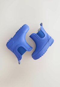 Mėlyni guminiai kulkšnies batai su tekstūruotomis šonais ir stambiais padukais, su elastingais skydeliais ir kilpomis patogiam nešiojimui.
