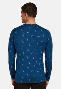 Dlouhý rukáv tričko v tmavě modré látce s opakujícím se světle modrým grafickým vzorem různých postav. Přiléhavý střih s kulatým výstřihem.