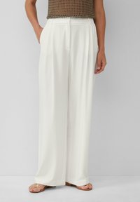 Pantaloni bianchi a gamba larga realizzati in tessuto morbido con una vestibilità sartoriale, dotati di tasche laterali e una vita piatta per una silhouette pulita.