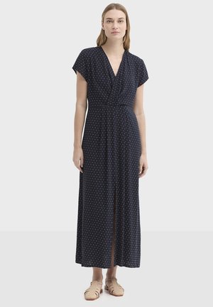 Robe longue bleu marine à motif à pois, col croisé, manches courtes et fente à l'avant. Confectionnée dans un tissu doux et léger.