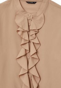 Blusa beige realizzata in tessuto leggero, caratterizzata da un design frontale con ruches, scollatura tonda e chiusura con bottoni. Texture liscia con un delicato riflesso.