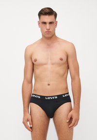 Culote negro de algodón con una cinturilla elástica de marca. El diseño es ajustado, con una textura suave y un corte estándar.