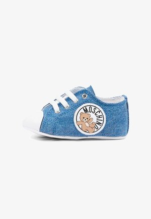 Zapato de bebé azul de mezclilla con punta blanca, cordones y un parche con logo de osito etiquetado "Moschino" en el lateral.