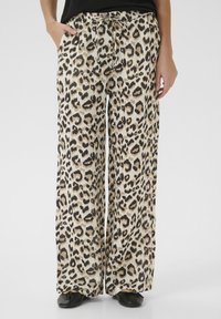Pantalons large en imprimé léopard avec une taille élastique et un cordon de serrage, présentant une base beige avec des taches noires et brunes. Texture lisse.