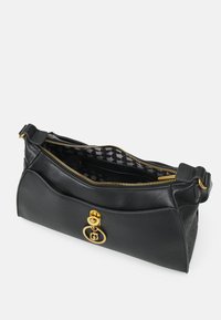 Borsa a spalla in pelle nera con hardware dorato, chiusura con zip e interni in tessuto a motivi con logo. Texture liscia con una forma strutturata.
