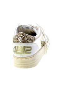 Sneaker bianco con accento glitter dorato sul tallone, tessuto testurizzato e suola beige. Presenta il numero "4812" sul lato.