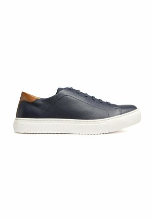 Basket en cuir bleu marine avec une semelle blanche épaisse et un patch marron au talon, vue de côté sur fond blanc.