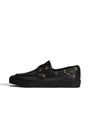 Zapato náutico de cuero Vans negro con ojales dorados, cordones decorativos y suela de goma negra, mostrado en perfil lateral.