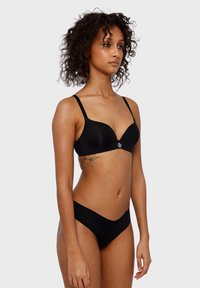 Czarny stanik i dopasowane figi bikini, wykonane z gładkiego materiału. Stanik posiada głęboki dekolt i regulowane ramiączka; minimalistyczny design z detalem logo.
