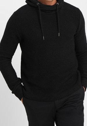 Felpa nera in cotone con motivo testurizzato, caratterizzata da un colletto alto e coulisse. Maniche lunghe, forma del corpo aderente e senza loghi visibili.