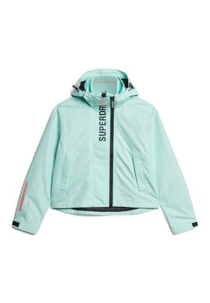 Lichtblauwe jas met ritssluiting en capuchon, zwarte ritssluiting, twee voorzakken, "SUPERDRY" tekst verticaal langs de rits, en "SUPERDRY SPORT" op linker mouw.