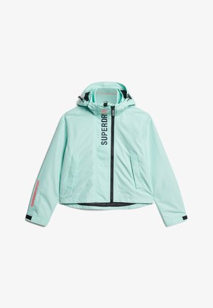 Chaqueta azul claro con cremallera y capucha, cremallera negra, dos bolsillos delanteros, texto "SUPERDRY" en vertical junto a la cremallera y "SUPERDRY SPORT" en la manga izquierda.