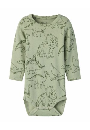 Zielone body niemowlęce z długim rękawem z czarnymi konturami ilustracji dinozaurów, w tym triceratopsa, stegozaura i pterodaktyla, z zatrzaskami na dole.