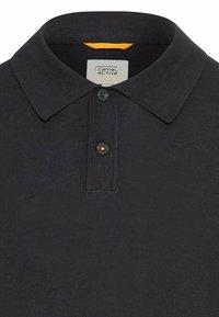 Sort polo t-shirt med ribbet tekstur, der har en krave, to knapper ved placket og en gul accent bag kraven.