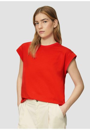 Rode katoenen t-shirt met korte opgerolde mouwen, een ronde halslijn en een relaxte pasvorm, gecombineerd met crèmekleurige broeken.