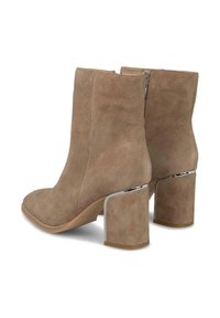Stivali alla caviglia in suede marrone chiaro con tacco a blocco accentuato in cromo. Presentano una parte superiore liscia e una cerniera laterale per una facile vestibilità.