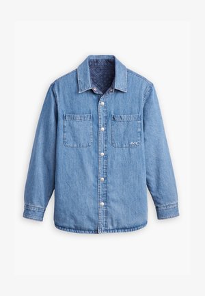 Chemise en denim de couleur bleu clair, fermeture à boutons sur le devant, deux poches poitrine et un doublure intérieure à motifs bleu foncé. Comprend un col.