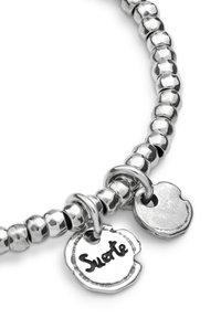 Pulsera de tono plateado con cuentas redondeadas, con dos dijes adjuntos: uno grabado con "Suerte" y otro dije liso.