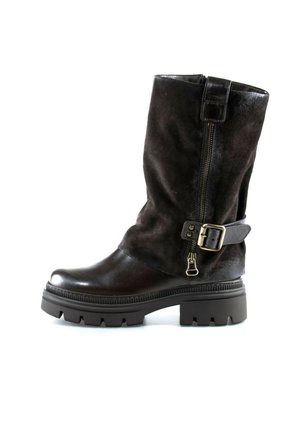 Schwarzer Stiefel bis zur Mitte der Wade mit dicker Gummisohle, seitlichem Reißverschluss und dekorativem Riemen mit Metallschnalle auf weißem Hintergrund.