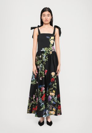 Svart blommig maxiklänning med en figurnära bodice, breda knytband och färgglada broderade blommor över kjolen. Slät textur och flödande design.