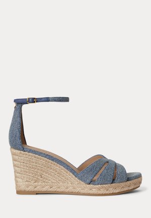 Niebieska sandałka na koturnie z denimu z plecioną platformą z juty, odkrytymi palcami, krzyżującymi się paskami i regulowanym zapięciem na kostce.