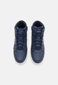 Sneakers alte in pelle blu navy con punta perforata, lacci tonali e suola in gomma bianca. Presentano il marchio sulla linguetta e dettagli laterali.