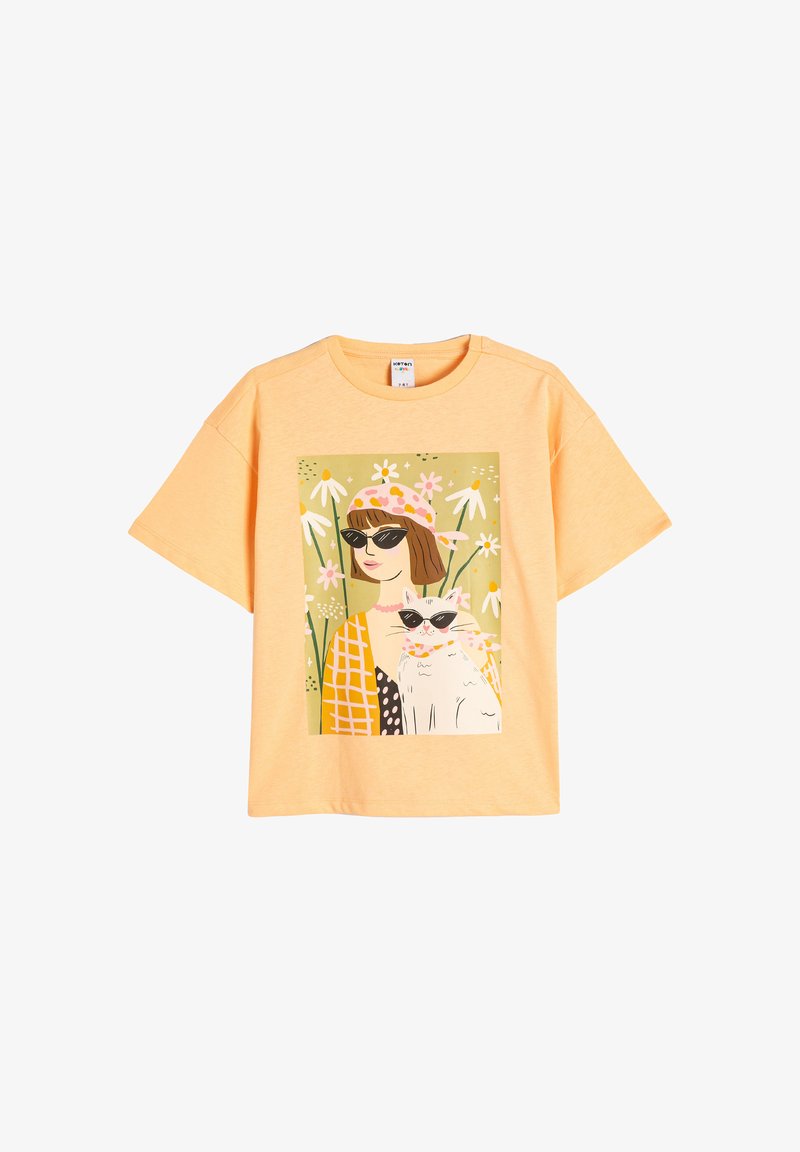 Gul bomulds T-shirt med et farverigt illustreret print af en kvinde og en kat, der bærer solbriller, omgivet af blomsterlige elementer.