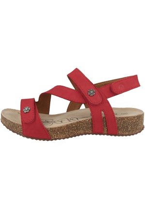 Rød sandal med åben tå med korksål, justerbare remme og små dekorative metalblomst-accenter på front- og ankelremme.