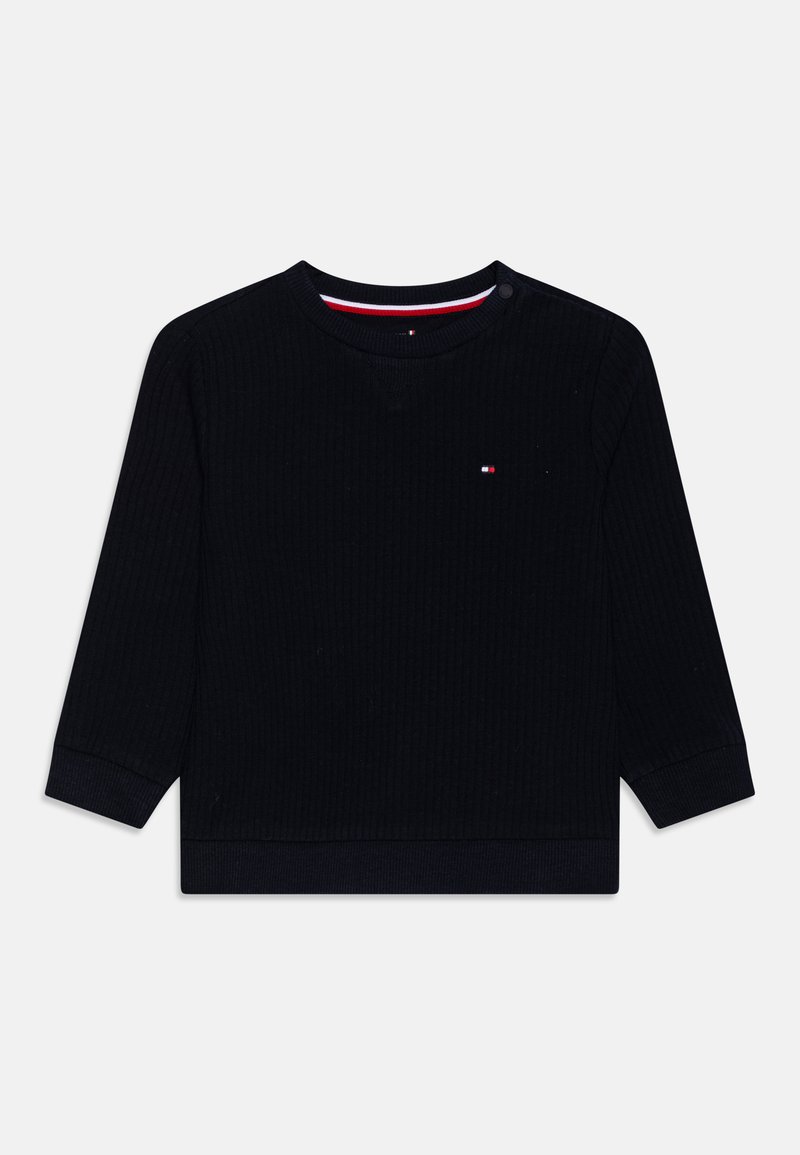 Maglietta a maniche lunghe ribbed blu scuro con scollatura rotonda e interno a contrasto, caratterizzata da un piccolo logo sul petto. Dettaglio con bottoni sulla spalla.