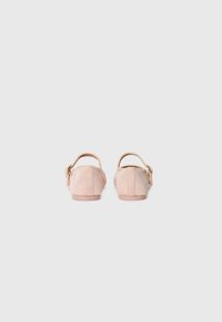 Chaussures à enfiler en tissu ribbed rose pâle, avec une sangle autour de la cheville et un détail de boucle. Semelles plates et douces avec un design à bout rond.